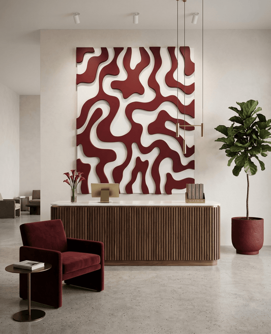 Modern interior with a red and white abstract wall art piece, a red armchair, and a potted plant.