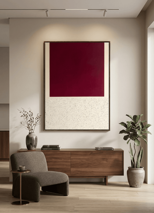 Modern interior with a wooden sideboard, gray chair, and abstract red painting.