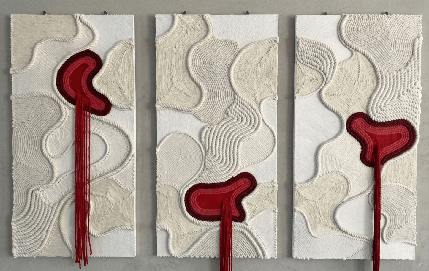 Three abstract wall art panels with red and beige patterns on a gray background